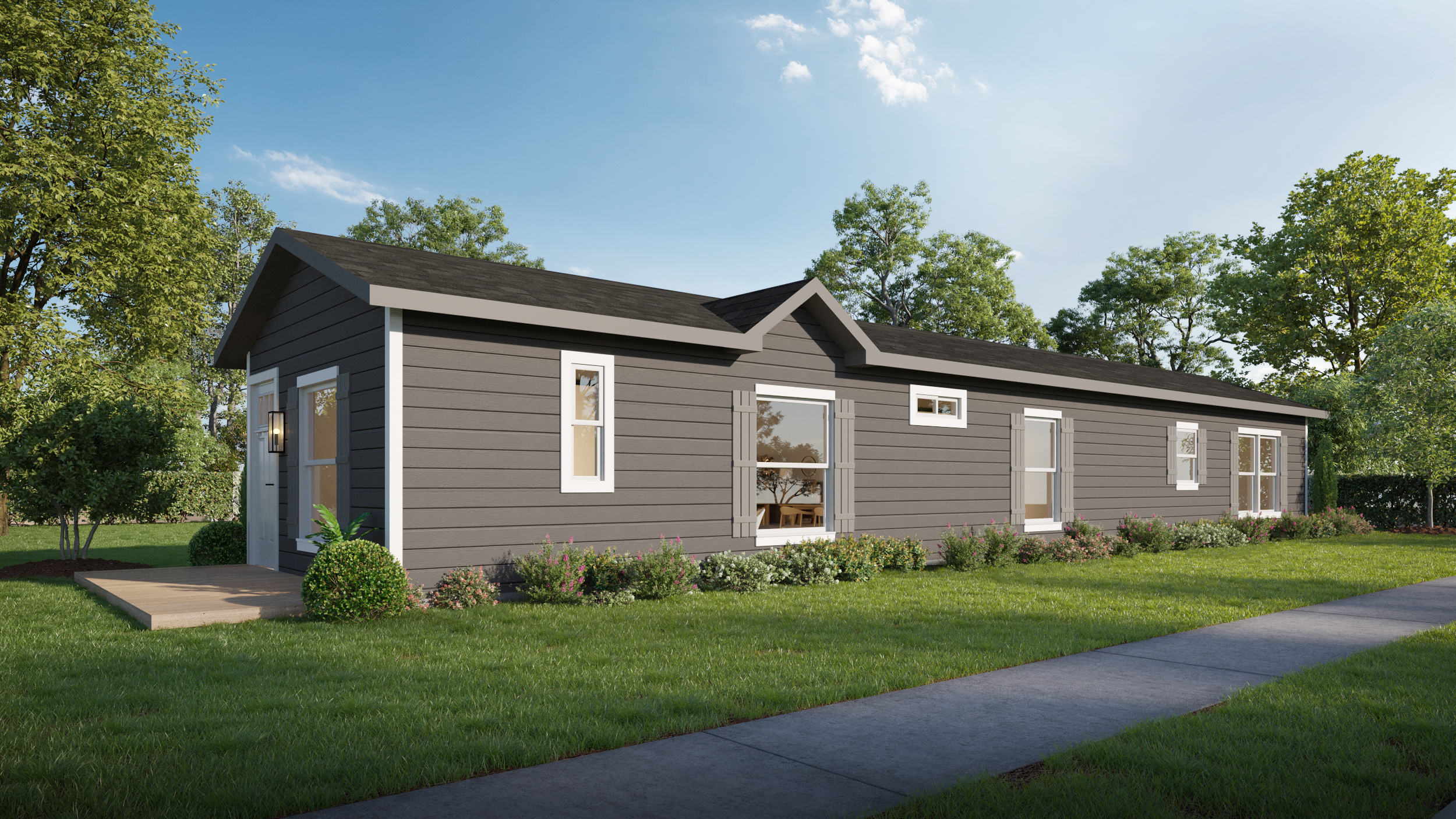 A modern, single-story modular home with dark gray siding and white trim, set in a grassy yard with trees and a sidewalk in the foreground.