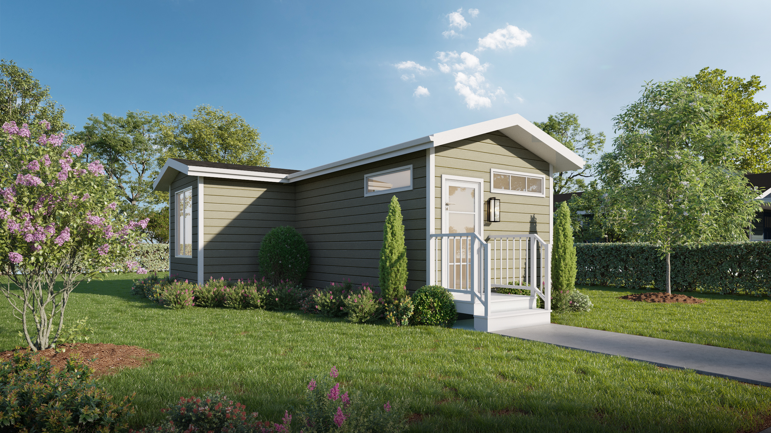 A small, modern green tiny house with white trim sits in a landscaped yard with trees, shrubs, and a concrete walkway leading to the front door.